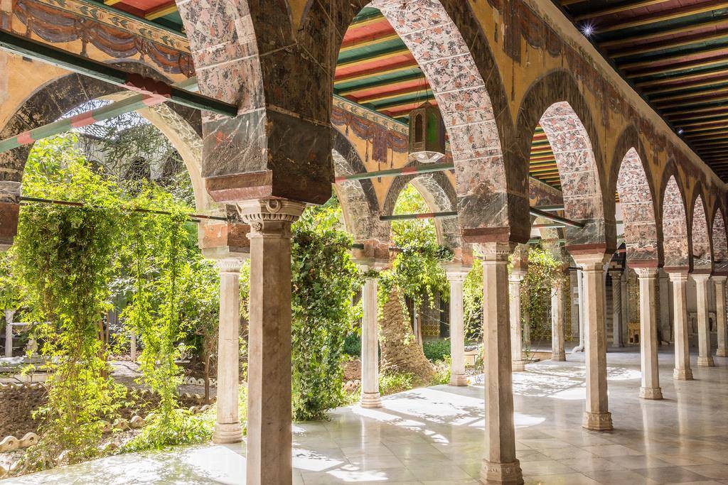 Tiled arches and a garden courtyard inside the Bey's Palace in Oran