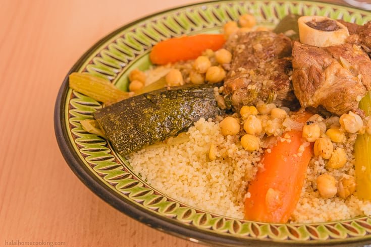 Algerian couscous with lamb, chickpeas, carrots and zucchini on a painted plate