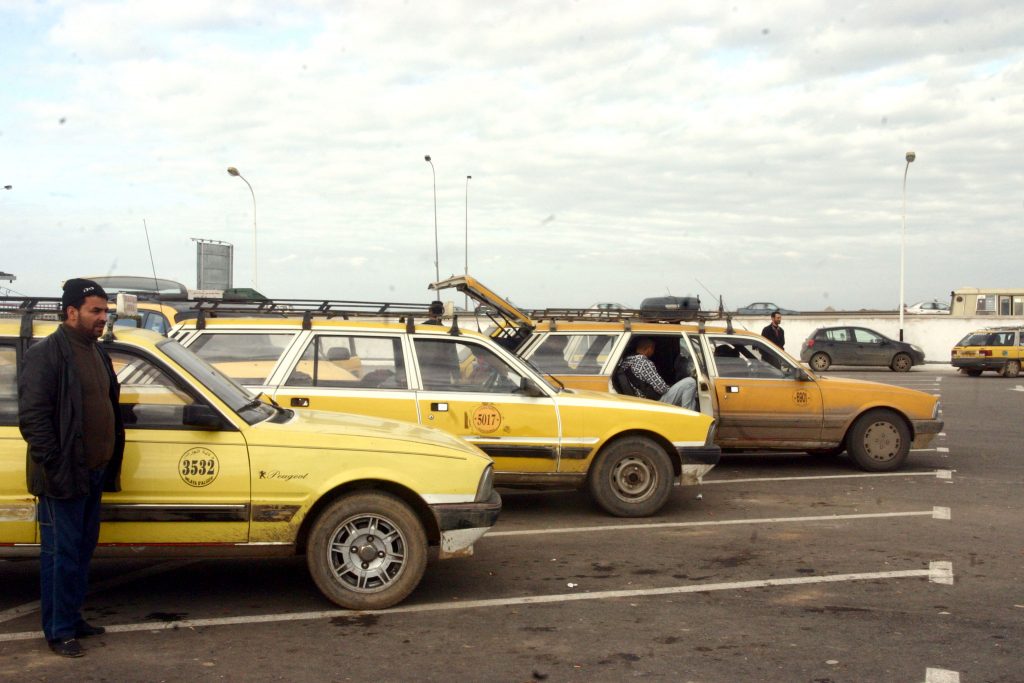 Yellow shared taxis lined up at a taxi station in Algeria