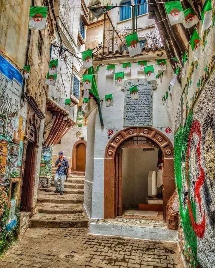 Whitewashed Casbah alley in Algiers decorated with strings of Algerian flags