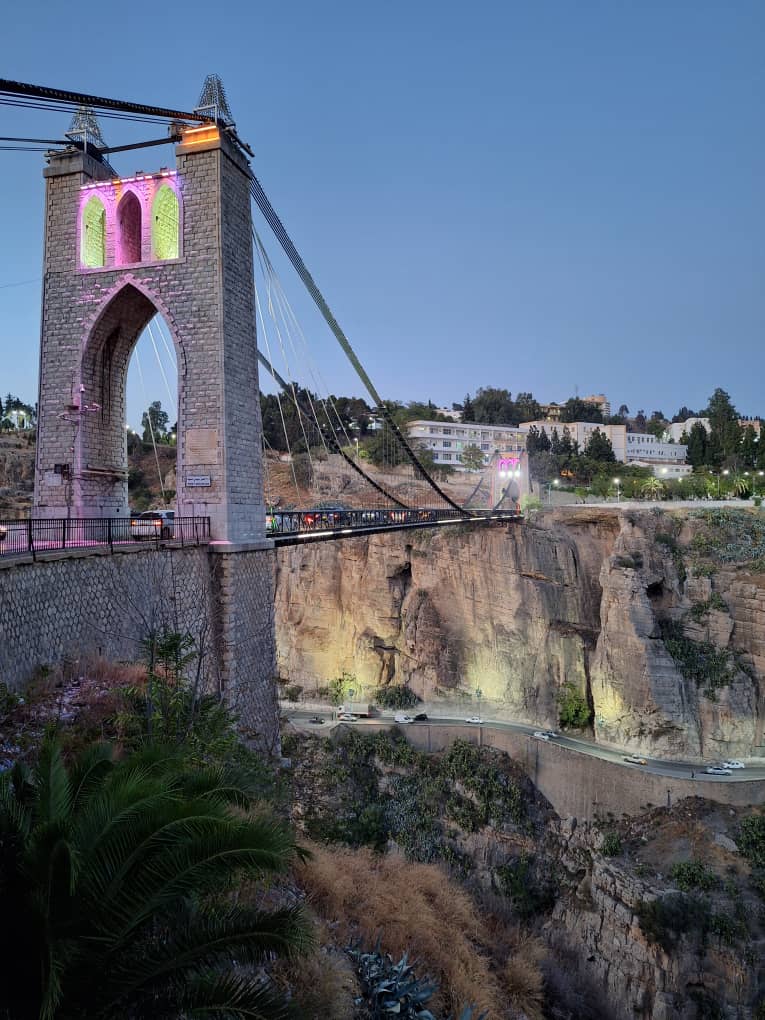 Sidi M'Cid bridge lit in pink and green at dusk over the Rhumel gorge
