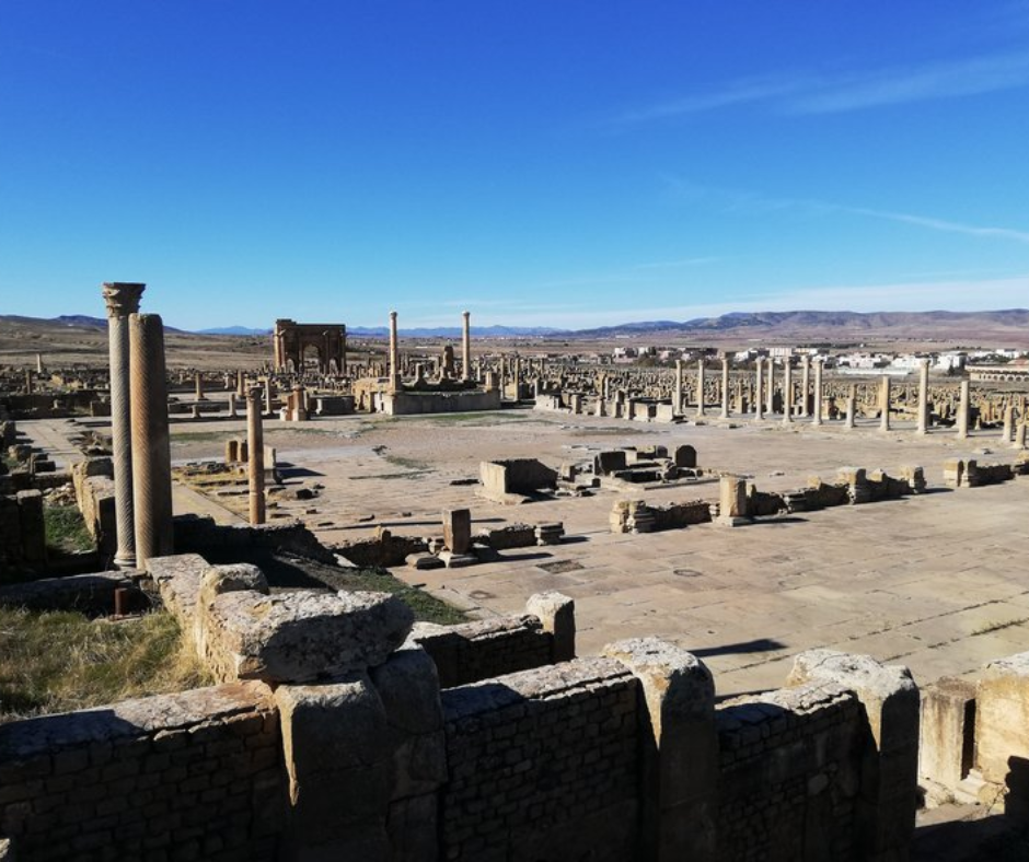 Wide view over the forum and ruins of Timgad under a clear blue sky
