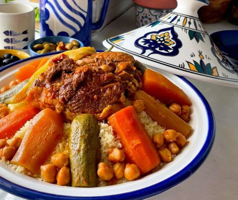 Couscous with lamb, carrots, zucchini and chickpeas in a blue-rimmed white bowl