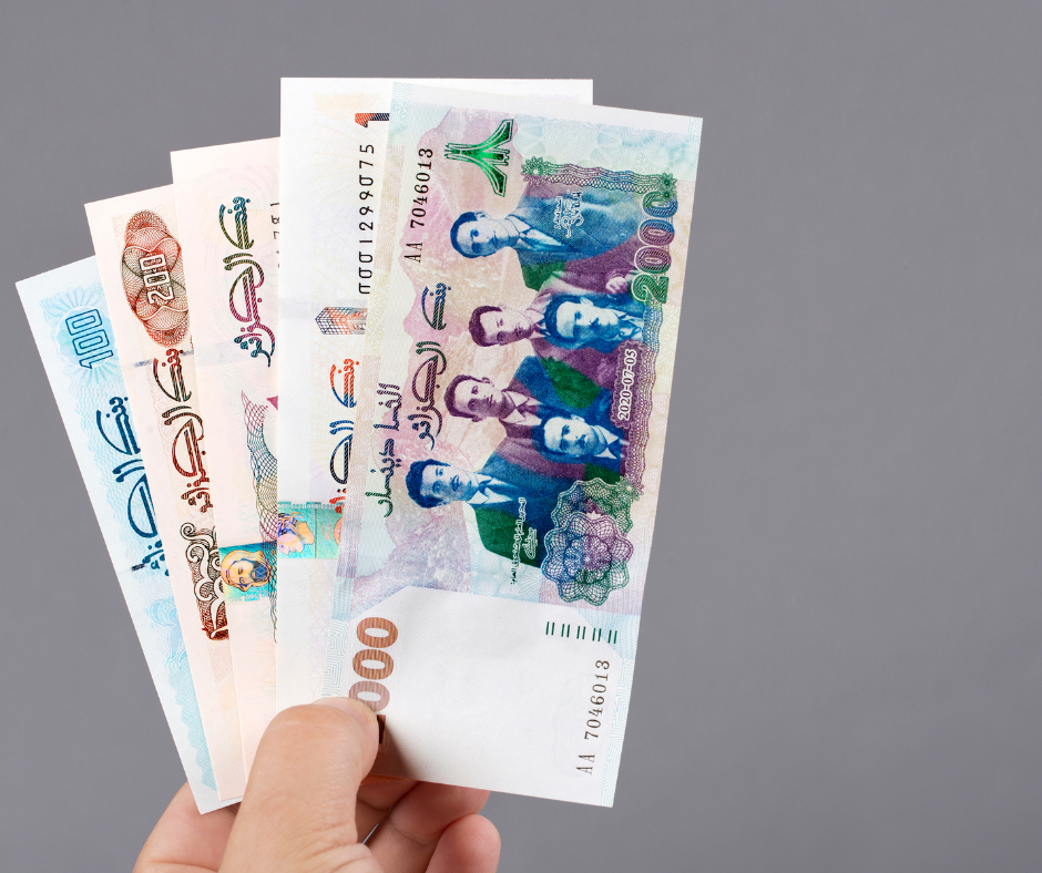 Fan of Algerian dinar banknotes held in one hand