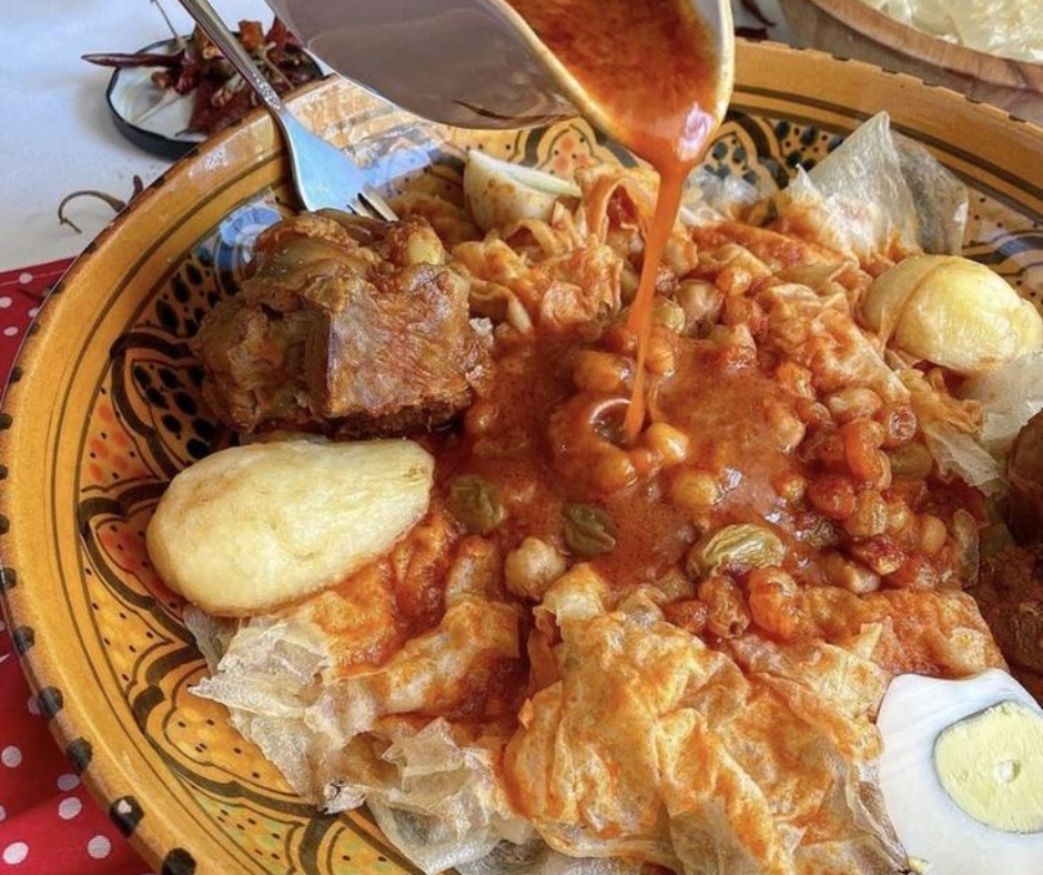 Chakhchoukha of torn flatbread with chickpeas, lamb, potato and boiled egg under spicy sauce