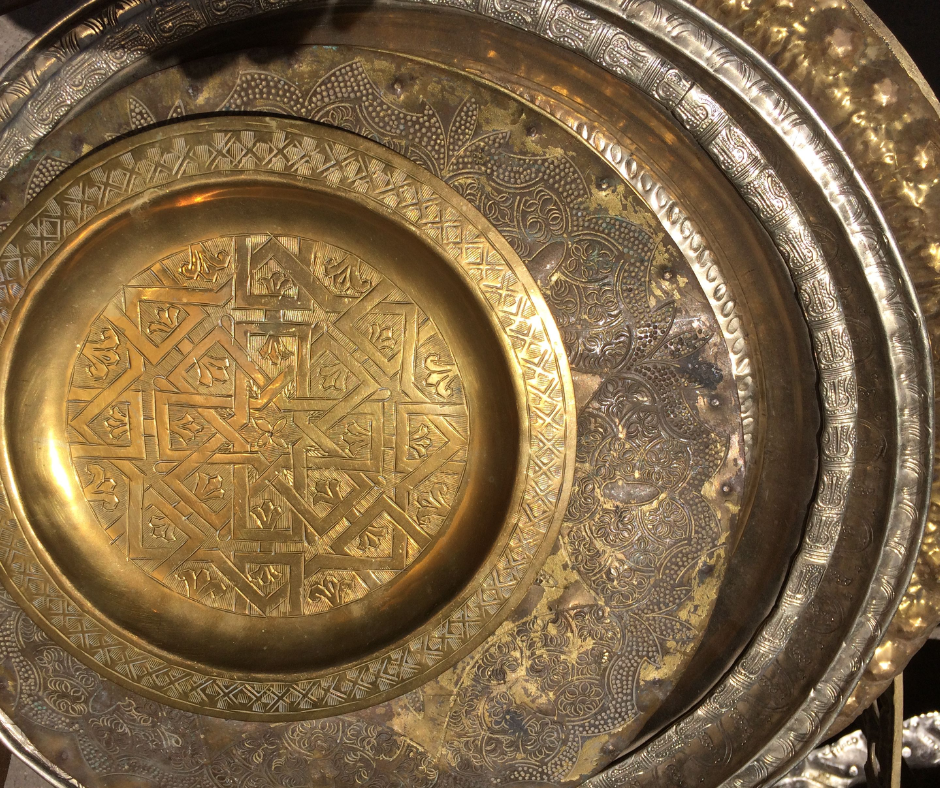 Stack of engraved brass trays with geometric patterns