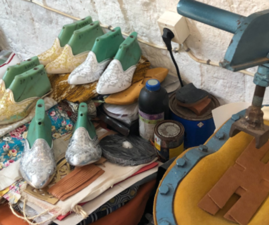 Leather slipper lasts and embroidered fabric on a shoemaker's workbench