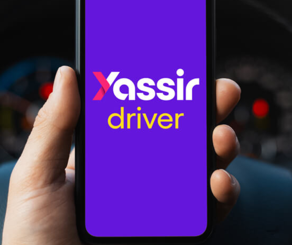 Hand holding a phone showing the Yassir driver app screen