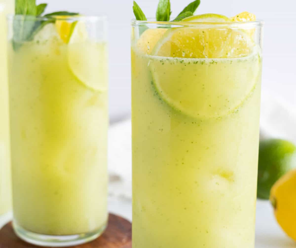 Tall glasses of lemon and mint drink with lime slices