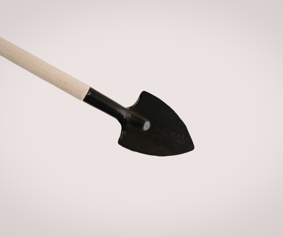 Small black garden shovel with a wooden handle on a white background