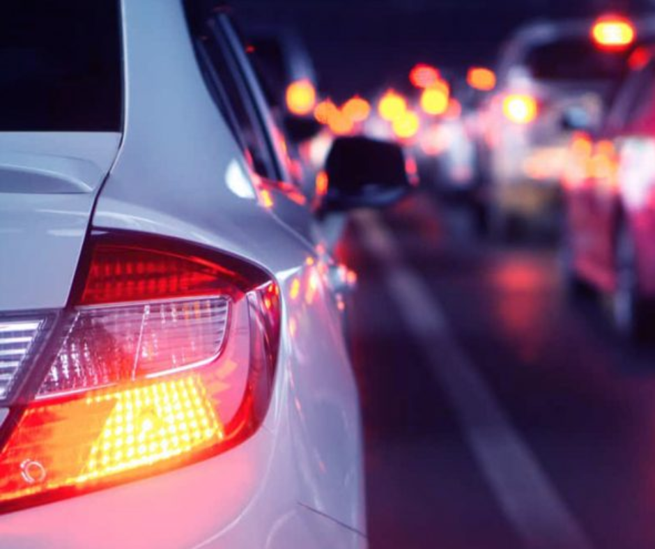 Car brake lights and blinker glowing in evening traffic