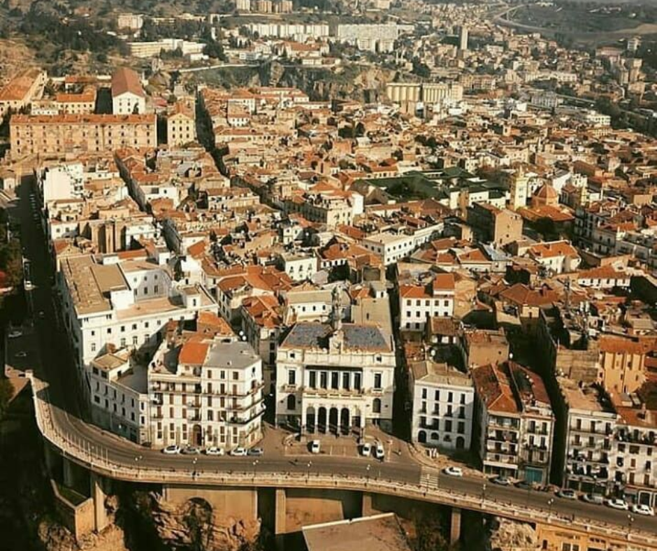 Aerial view of Constantine's old town rooftops and a curving road viaduct