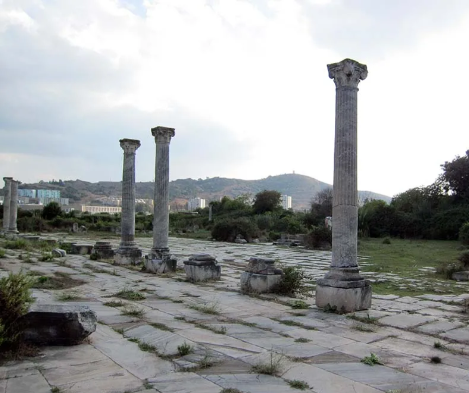 Paved forum with standing columns at Hippo Regius and Annaba's hills behind