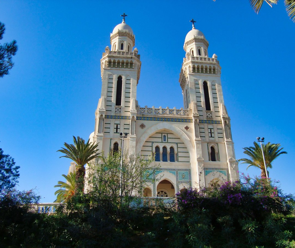 Twin-towered white Basilica of Saint Augustine against a blue sky in Annaba
