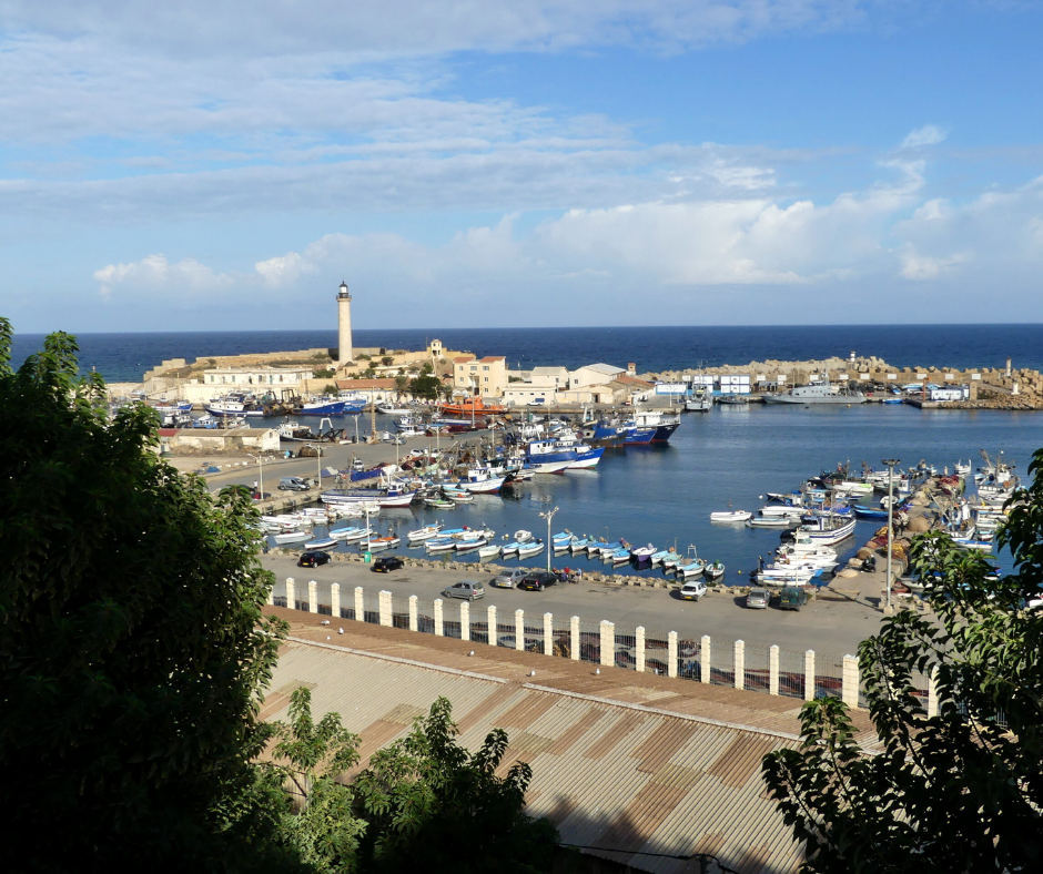 Harbor with fishing boats and a lighthouse on the coast at Cherchell