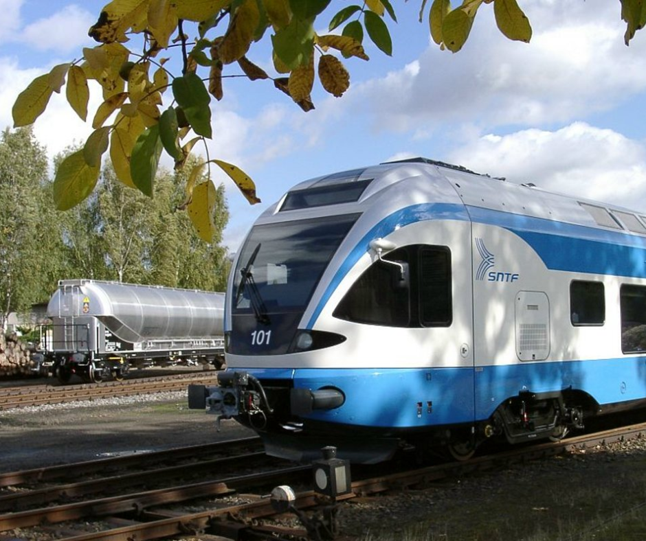 Blue and white SNTF passenger train at a station