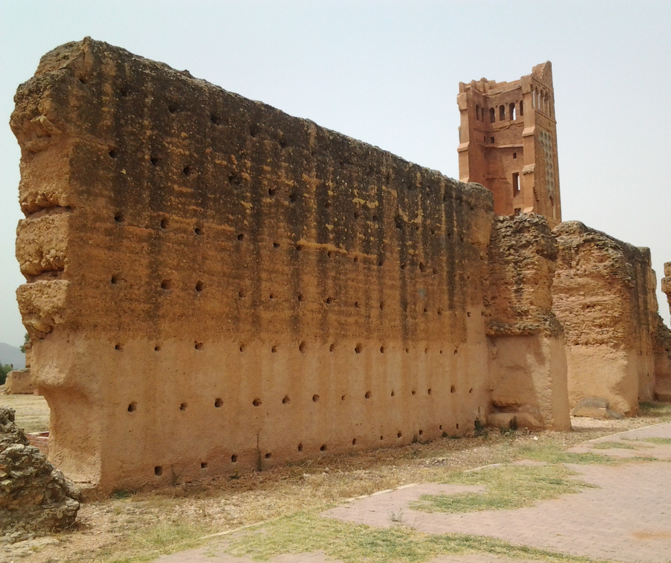 Tall ruined earthen walls and the red minaret of Mansourah near Tlemcen