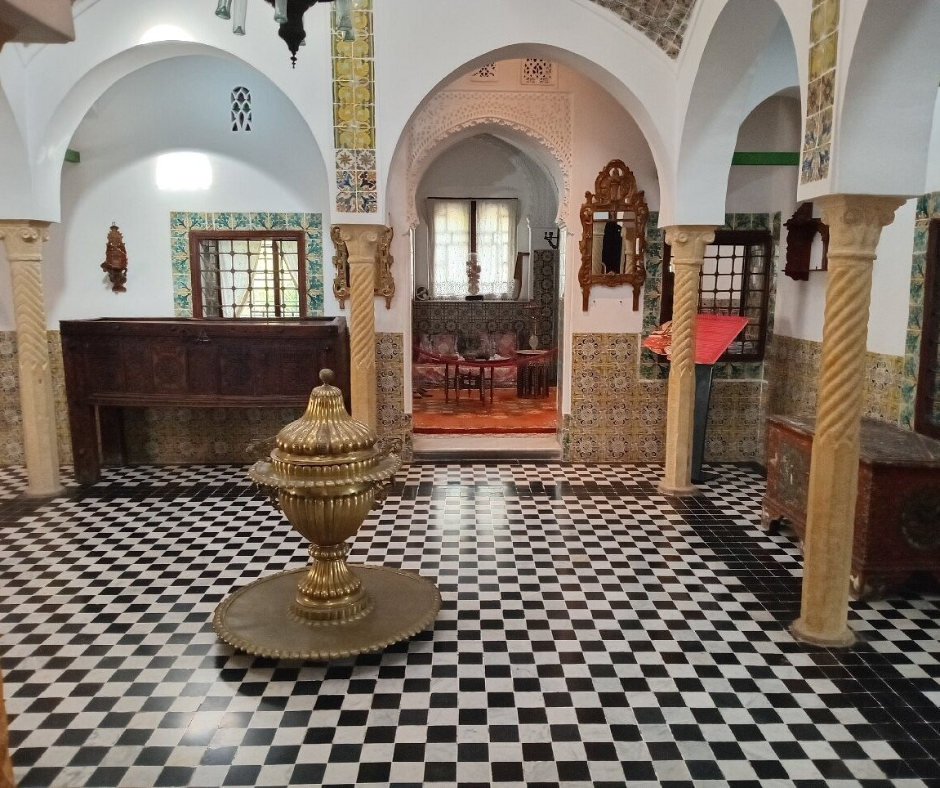 Casbah palace-style hall with a black and white floor, brass fountain and tiled walls