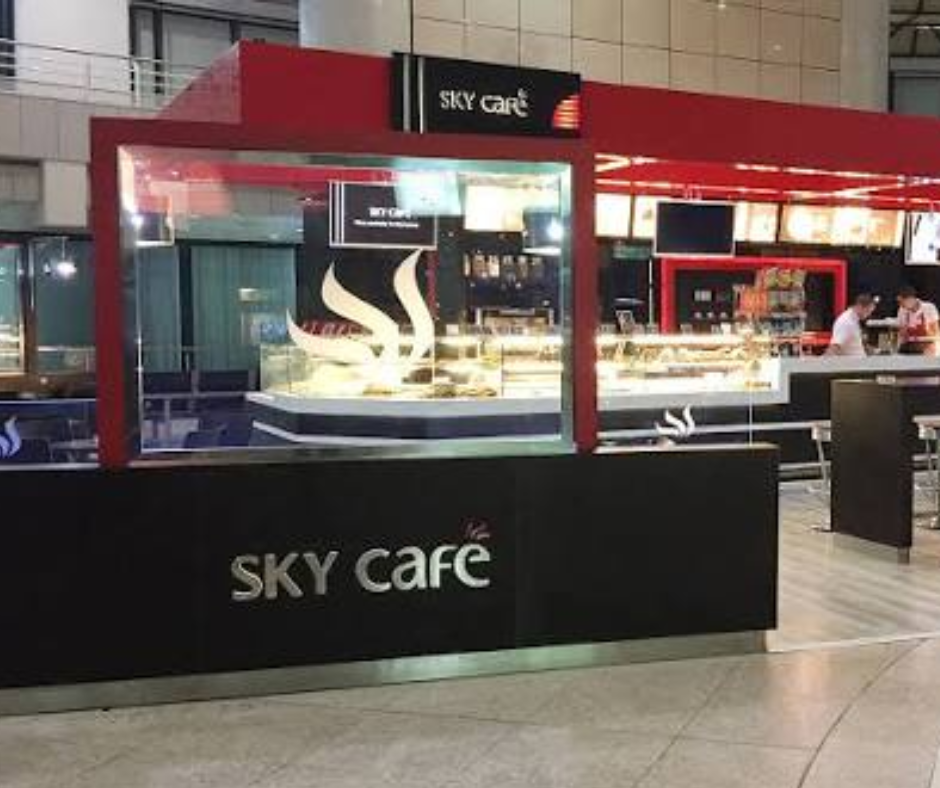 Sky Café kiosk with a pastry display counter in an airport hall