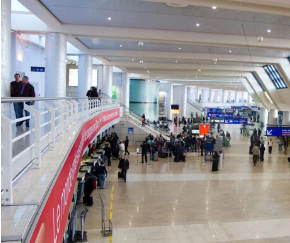 Arrivals hall of Houari Boumediene Airport in Algiers with travelers and luggage