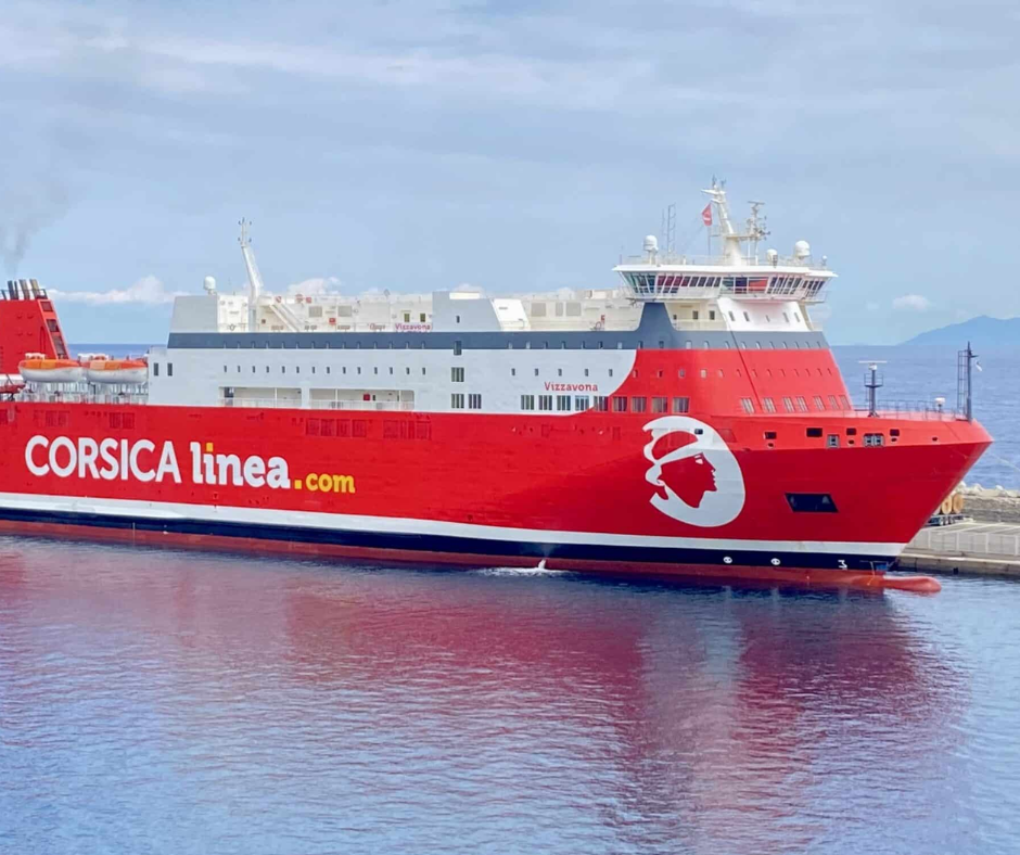 Red Corsica Linea ferry moored in a port on calm water