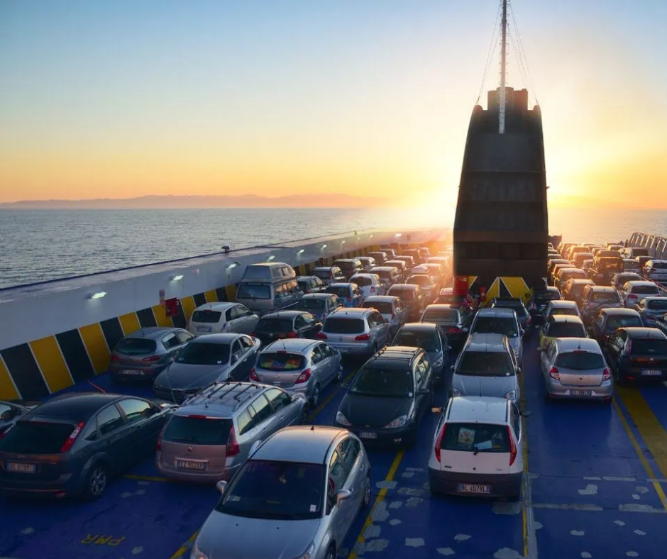 Cars parked on the car deck of a ferry at sunset
