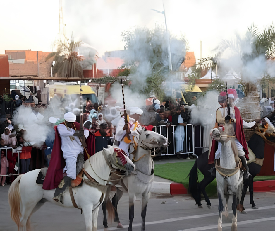 Horsemen in traditional dress and capes firing a salute on white horses