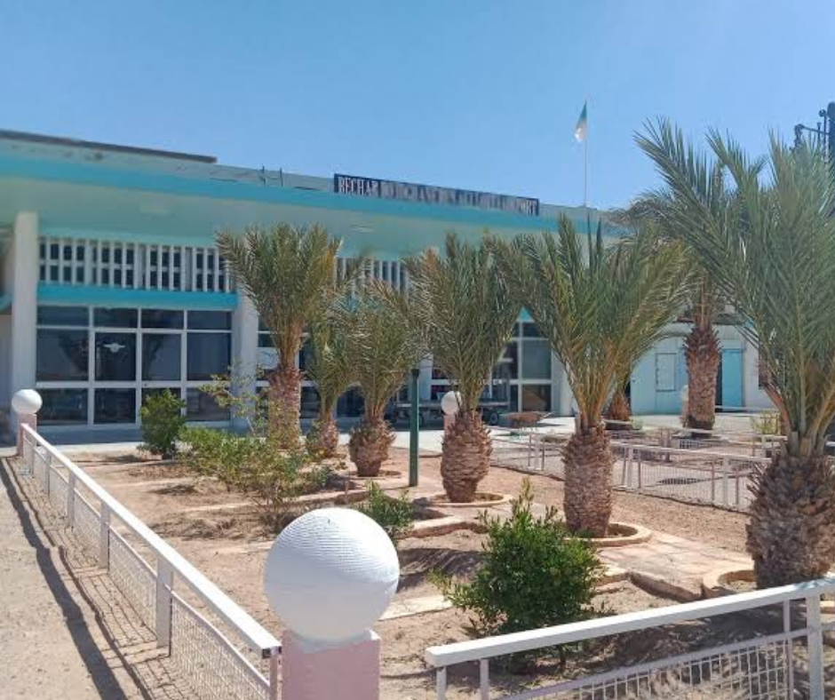 Low terminal building with palm trees at Béchar airport