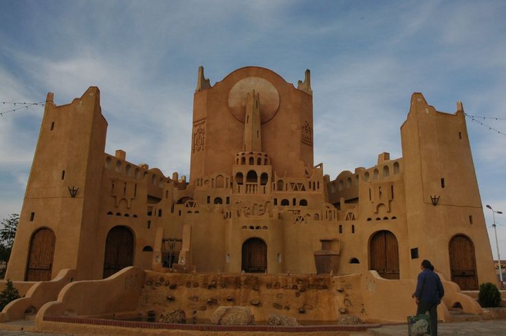 Large ochre building in Mozabite style with corner towers and a central spire